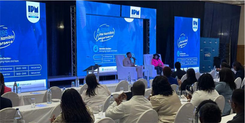 Professional indoor stage setup for the IPM Namibia Conference at Mercure Hotel featuring large-scale LED video walls and panel discussion seating.