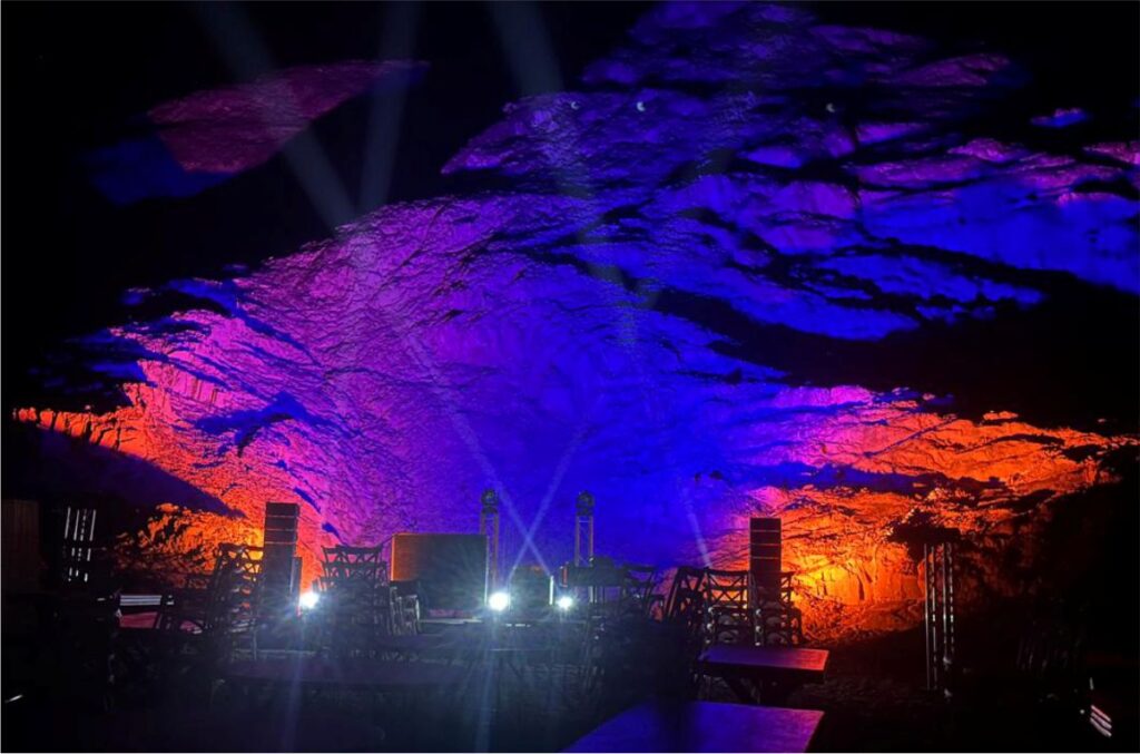Large scale architectural wall wash lighting in blue and orange for an outdoor event or concert.